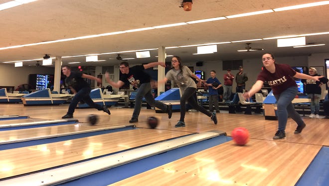 From left, Lansing varsity bowlers Cole Quigley, Brandon Drake, Ekartina Wilson and Lizzie Ferrer  “push the ball to the mark” at the team's "home lanes," Helen Newman Bowling Center at Cornell University.
