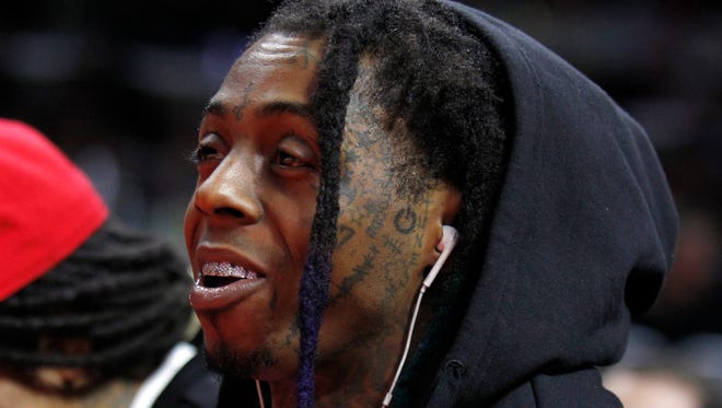 Rapper Dwayne Michael Carter, Jr., known by his stage name Lil Wayne, looks on in the first half of an NBA basketball game between the Detroit Pistons and the Los Angeles Clippers in Los Angeles, Monday, Dec. 15, 2014.
