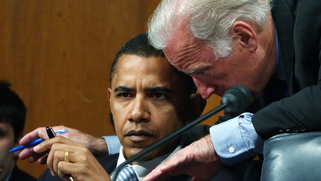 Then-senators Obama and Biden confer during a Foreign Relations Committee hearing on Capitol Hill on April 11, 2005, on John Bolton's nomination to be ambassador to the United Nations.