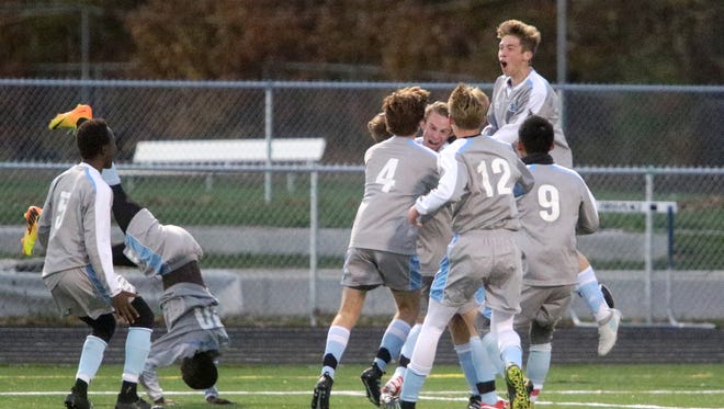 The South Burlington Wolves celebrate senior Patrick O'Hara's game winning goal against Burlington. O'Hara's goal sent the Wolves to the D1 final on Saturday where they will face off against St Johnsbury.