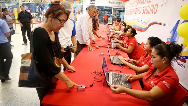 Shoppers register their fingerprints at Bicentenario, Plaza Venezuela in Caracas. The government has implemented a fingerprinting system to prevent hoarding of basic goods.