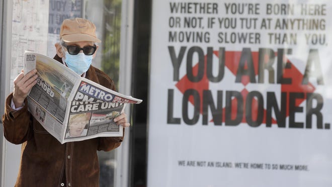 A man reads a newspaper with the headline: 'PM in intensive care', outside St Thomas' Hospital in central London as British Prime Minister Boris Johnson is in intensive care fighting the coronavirus in London, Tuesday, April 7, 2020. Johnson was admitted to St Thomas' hospital in central London on Sunday after his coronavirus symptoms persisted for 10 days. Having been in hospital for tests and observation, his doctors advised that he be admitted to intensive care on Monday evening. The new coronavirus causes mild or moderate symptoms for most people, but for some, especially older adults and people with existing health problems, it can cause more severe illness or death.(AP Photo/Kirsty Wigglesworth)