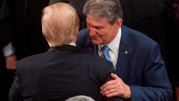 President Donald Trump embraces Sen.Joe Manchin, Democrat