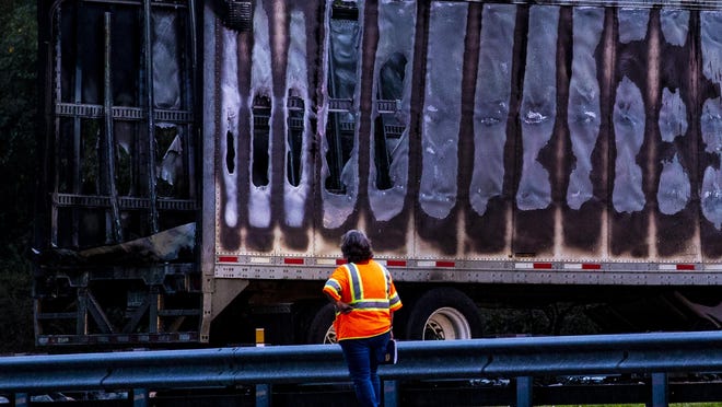 In this Thursday, Jan. 3, 2019, file photo, a worker looks at a charred semitrailer after a wreck with multiple fatalities on Interstate 75, south of Alachua, near Gainesville, Fla.