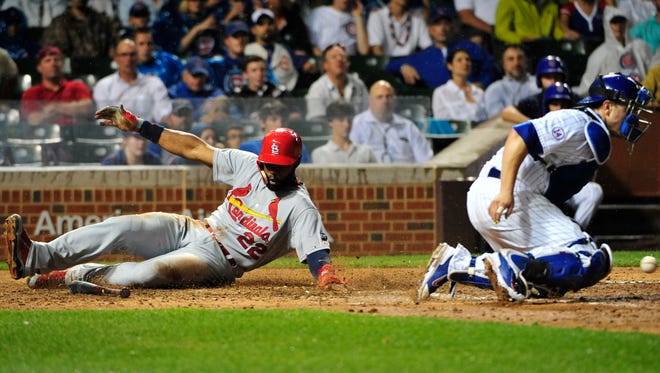 St. Louis Cardinals'  Jason Heyward, left, slides safely into home plate as Chicago Cubs catcher Miguel Montero, right, takes the throw during the seventh inning of a baseball game, Monday, July  6, 2015, in Chicago. (AP Photo/David Banks) 