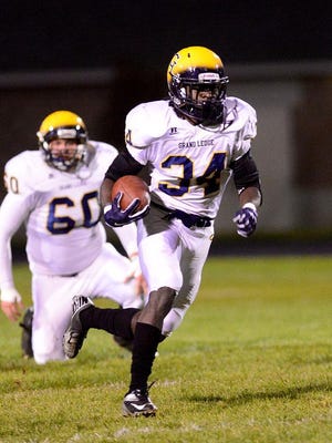 Grand Ledge's Ba Blamo pulls away from the Holt defense on his way to the second of his two first-half touchdowns at Holt High School, October 23, 2015 in Holt, Michigan.
