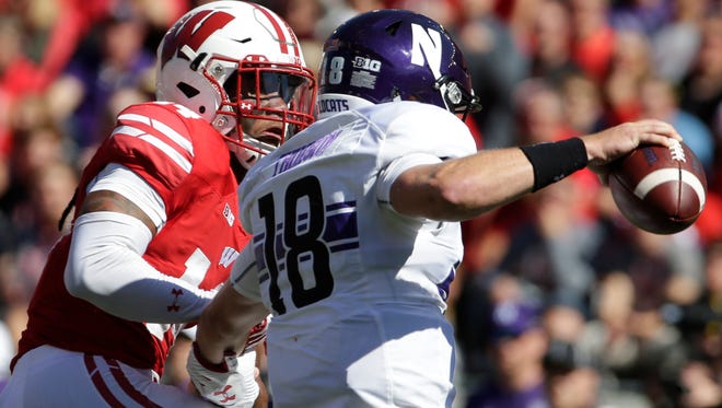 Northwestern quarterback Clayton Thorson turns a potential sack by Wisconsin safety D'Cota Dixon into a 3-yard gain during the third quarter Saturday.