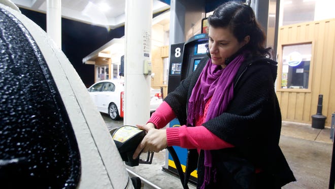 Corina Gilden fills up a family car at a Valero gas station at Milltown and McKennans Church Roads early Tuesday evening.