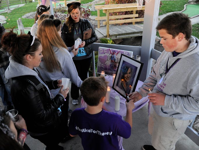 Members of the DeKeyzer family light candles at the