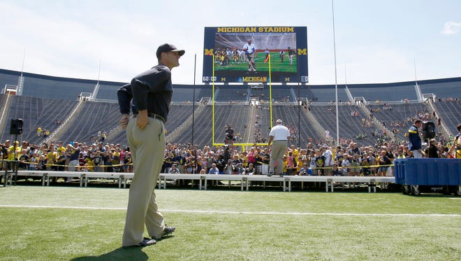 Michigan head coach Jim Harbaugh oversees the  introduction of the team's players by position group to the fans during football media day on Thursday, August 6, 2015, in Ann Arbor.