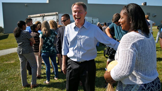 Mayor Joe Hogsett, left, laughs with Sirrea Whittaker at the ceremony opening the new urban farm partnering The Finish Line, Inc. and Brandywine Creek Farms, Thursday, August 23, 2017.