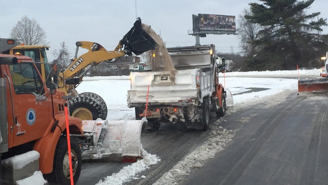 A DelDOT snow plow gets resupplied with salt to sprinkle onto the roadway.