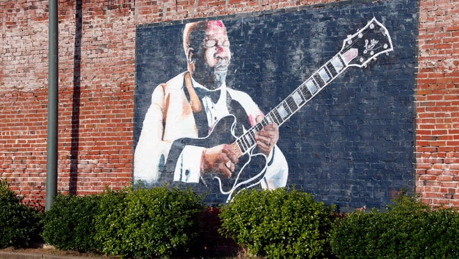 In this photo taken May 6, 2015,  a wall mural of B.B. King overlooks a downtown parking area in Indianola, Miss. King claimed Indianola as his hometown after moving there as a teenager. The influence of the acclaimed "King of the Blues," is seen throughout the small Mississippi Delta town. King died Thursday night, May 14, 2015, at age 89 in Las Vegas, where he had been in hospice care. (AP Photo/Rogelio V. Solis)