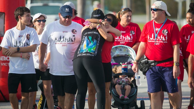 Lauren Harkins hugs Linda Beni at the start of the Walk Like MADD 5K on Saturday at JetBlue Park. Harkins, who is the chair of the event, lost her brother in 2015 hit-and-run, and Beni’s daughter Brittany was killed in what is believed to be a drunken driving crash also.