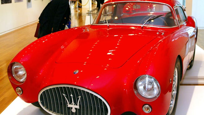 A Japanese sports car fan admiring a Maserati A6GCS Berlinetta Pininfarina