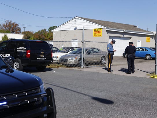 Police investigate the scene of the shooting at 28th Street Auto Sales and Services on the corner of E 28th and Northeast Boulevard in 2017.