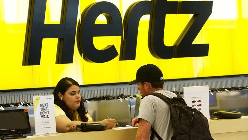 A Hertz employee helps Joe Shanahan, from Cape Cod as he rents a vehicle from the rental car giant on Oct. 24, 2013.