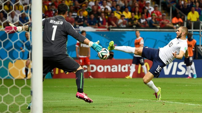 
France’s Karim Benzema (right) shoots to score the team’s fourth goal past Switzerland goalkeeper Diego Benaglio during their World Cup Group E match Friday at the Fonte Nova arena in Salvador.
