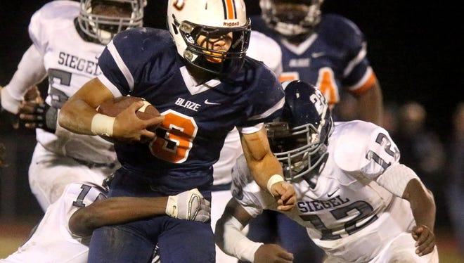 Blackman's Taeler Dowdy (3) is tackled by Siegel's Justin Perry (15) and Gef Elder (12) on Friday.