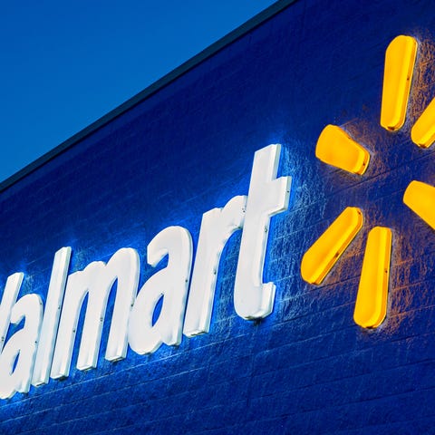 The Walmart sign lit up on the exterior of a Walma