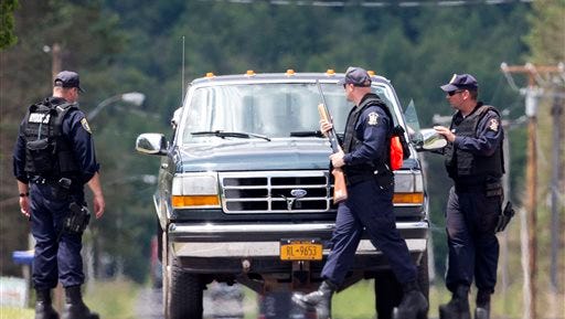 Corrections officers stop a vehicle as the search for two escaped prisoners from Clinton Correctional Facility in Dannemora continues Monday, June 22, 2015, in Owls Head, N.Y. Searchers on Monday swarmed the heavily wooded area about 20 miles west of the maximum-security Clinton Correctional Facility. (AP Photo/Mike Groll)