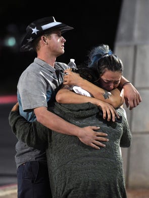 People hug and cry outside the Thomas  Mack Center.