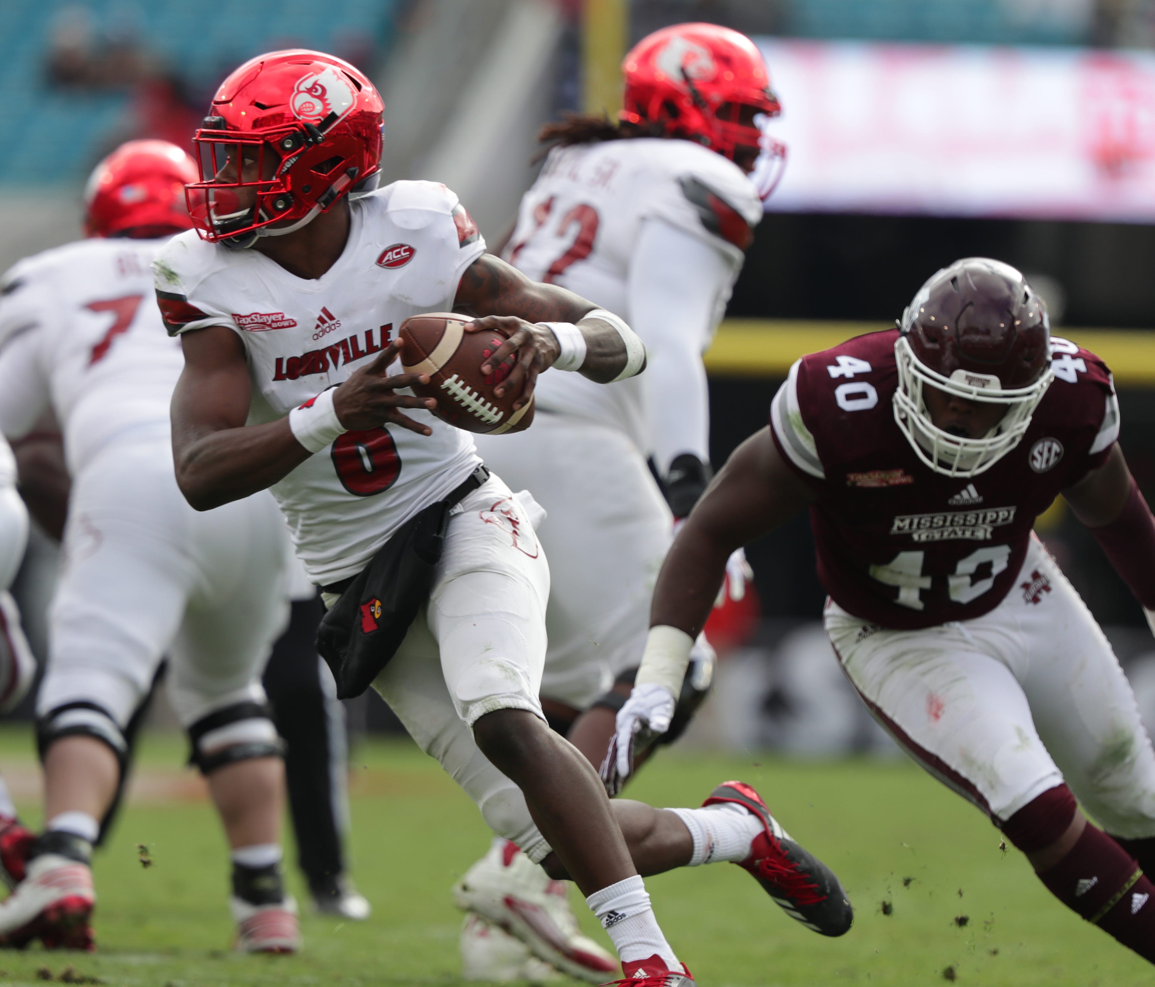Louisville's Lamar Jackson scrambles to avoid a sack in the second half of the TaxSlayer Bowl against Mississippi State. Dec. 30, 2017