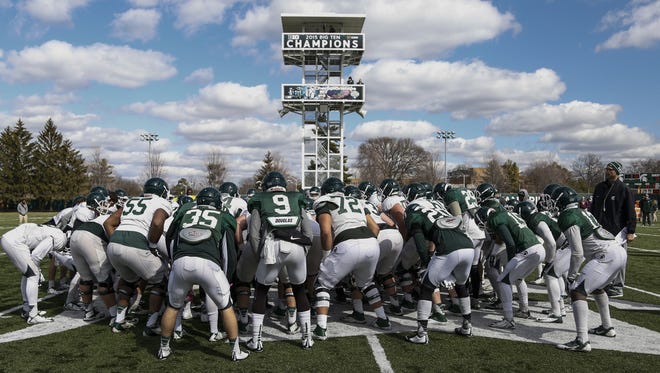 MSU players huddle up before practice Tuesday in East Lansing. The Spartans play their annual Green and White intrasquad scrimmage next Saturday in Spartan Stadium.