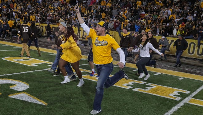 Wyoming Cowboys fans rush the field after an Oct. 26, 2016 football win against Boise State at War Memorial Stadium.