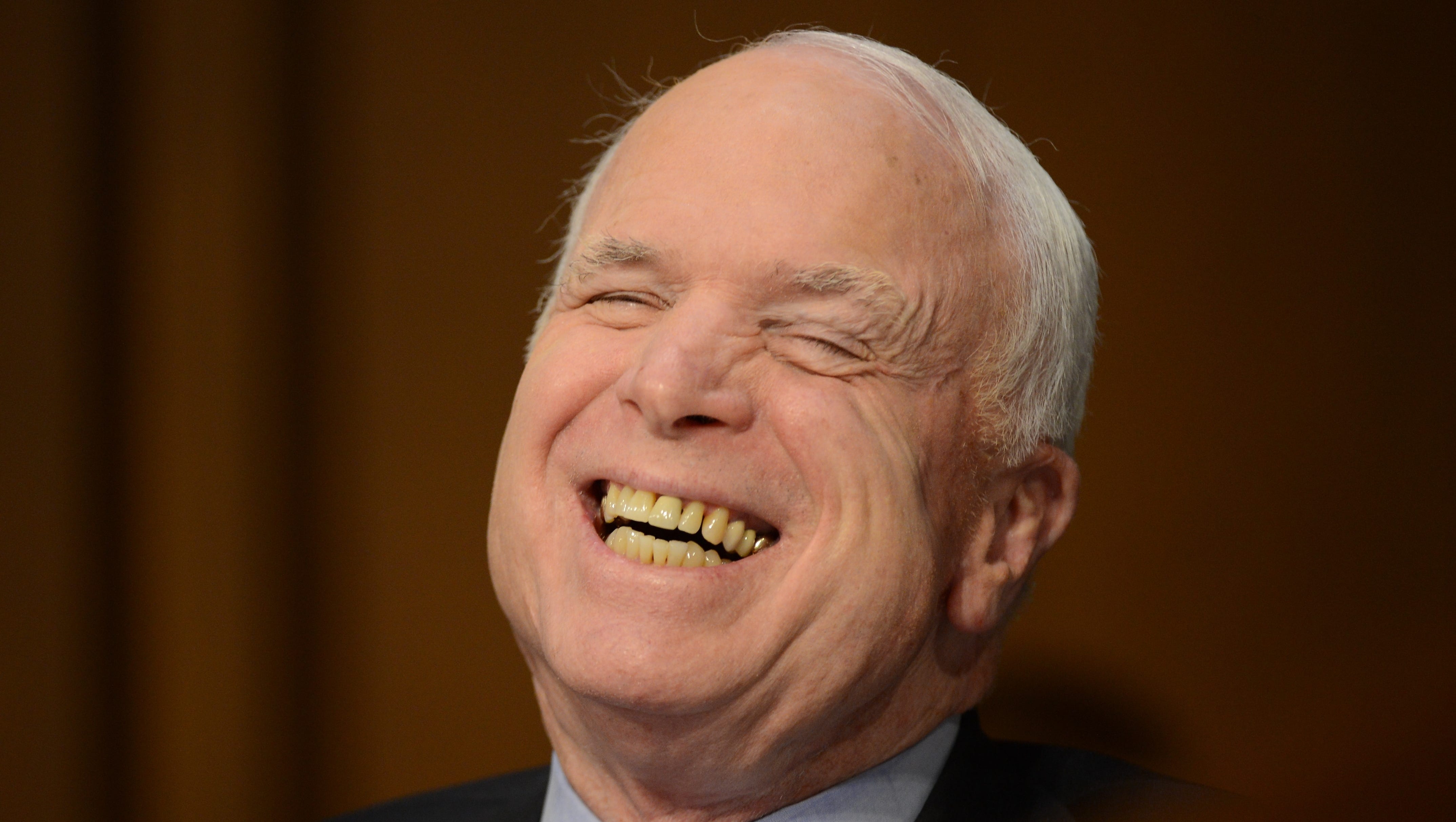 Sen. John McCain laughs during an exchange with Secretary