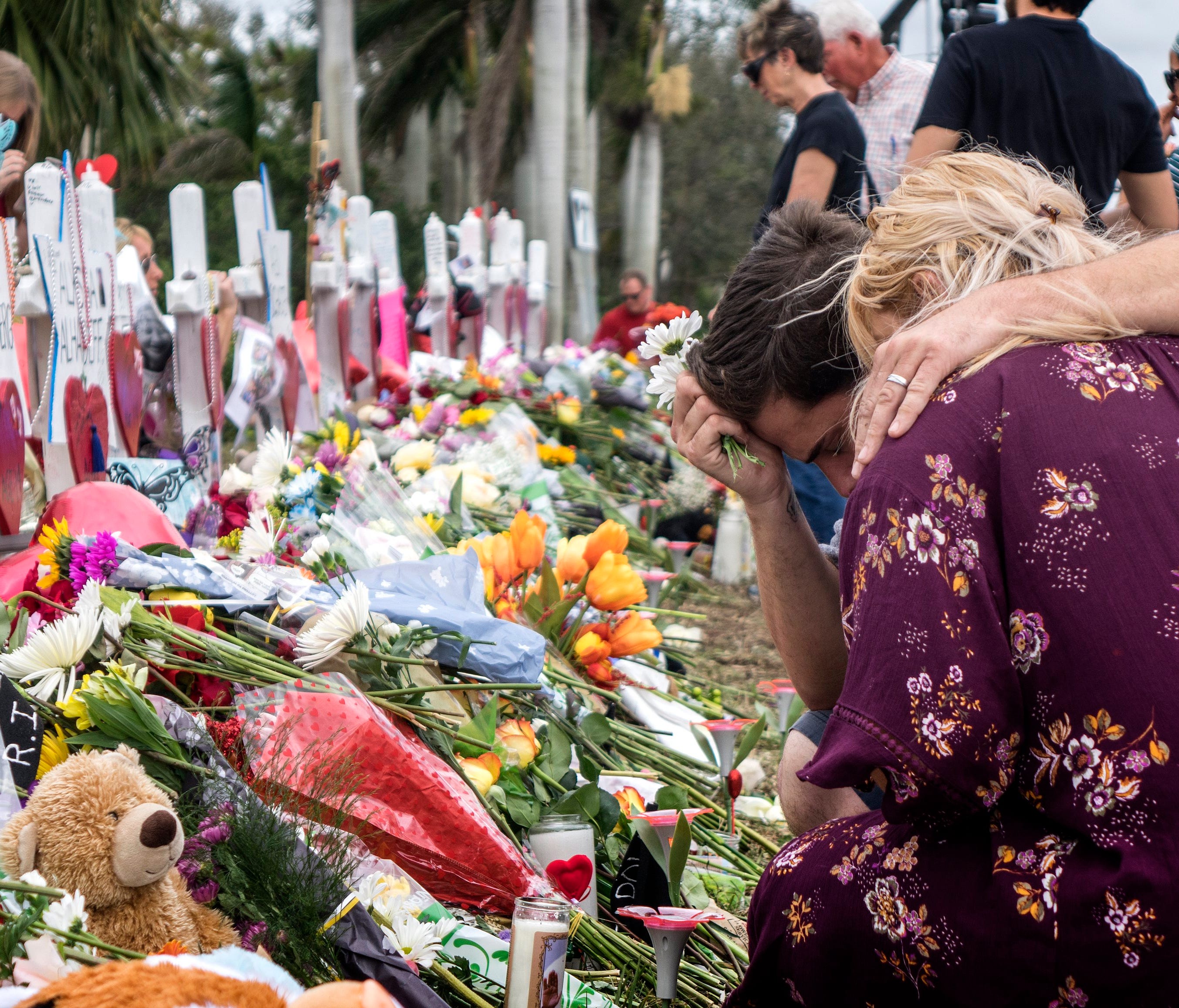 People visit a makeshift memorial in front of the Marjory Stoneman Douglas High School in, Parkland, Florida on Feb. 20, 2018.