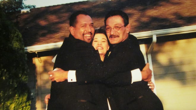 Fabian, left, and David Gonsalez hug Deanna Gonsalez at Fabian and Deanna’s wedding.