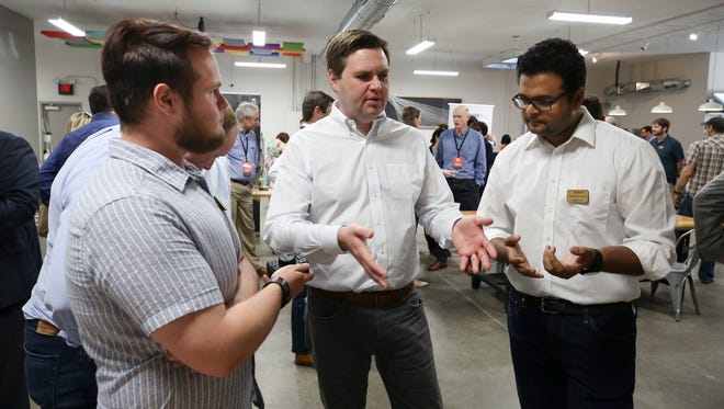 Author and venture capitalist J.D. Vance, center, spoke with Ben Douglas, left, and Ashok Seetharam, right, both of Toggle Health, as they demonstrated a wireless controller that is designed to allow doctors to quickly and safely access data during surgery.  The were at the Startup Crawl event at Maker13 in Jeffersonville.  Local inventors showcased their technology at the event.May 11, 2018