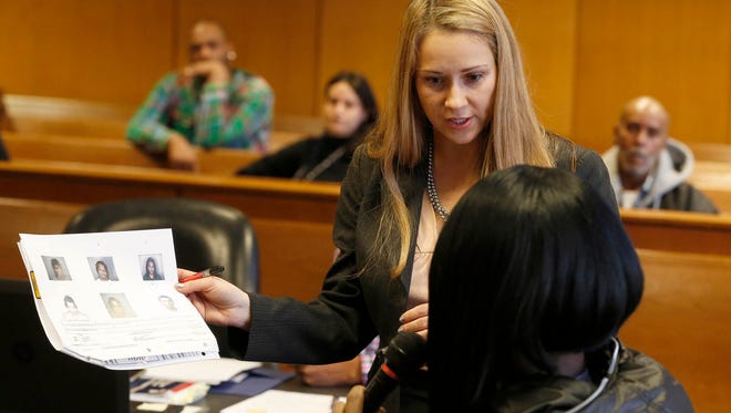 Prosecutor Jaimie Powell-Horowitz shows pictures to Sharita Maxwell on the witness stand during the preliminary exam for Jujuan Williams and Charles Brown in front of Judge Langston Lewis at the Frank Murphy Hall of Justice in Detroit on Wed., Dec. 13, 2017. The men were alleged to have robbed and shot Maxwell, a transgendered woman in November. 