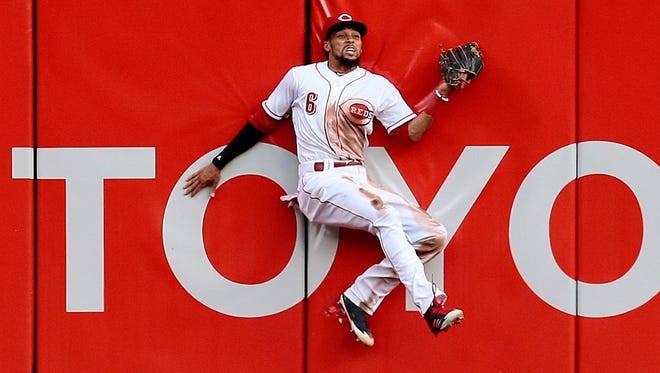 Cincinnati Reds center fielder Billy Hamilton (6) bounces off the right-centerfield wall as he catches a deep fly ball off the bat of Milwaukee Brewers right fielder Domingo Santana (16) in the top of the second inning of the MLB National League game between the Cincinnati Reds and the Milwaukee Brewers at Great American Ball Park in downtown Cincinnati on Thursday, April 13, 2017.