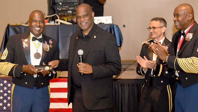 Mayor Reggie Tatum presents Command Sergeant Major Darrell Minix with a key to the city during a retirement gala honoring Minix, held at the Opelousas Civic Center on Saturday night.