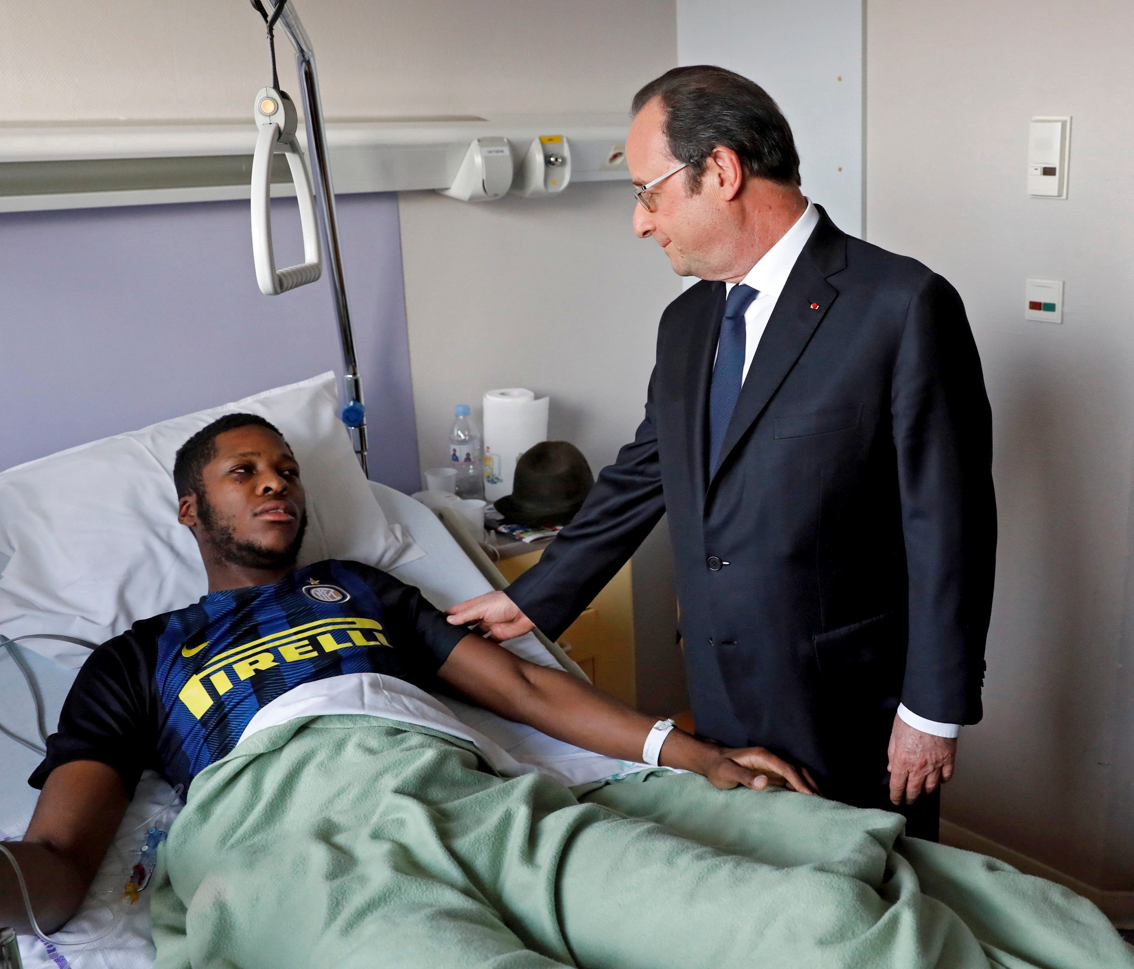 A handout photo made available by French newspaper Le Parisen on Feb. 8, 2017, shows French President Francois Hollande,right, visiting a man identified by police only as Theo at the Robert Ballanger hospital in Aulnay-sous-Bois, a suburb of Paris, o