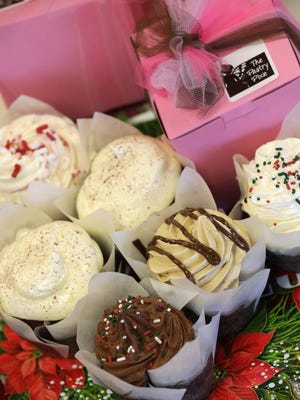 The Pastry Pixie in downtown Neenah wraps up holiday cupcakes in a pink box tied with a bow.