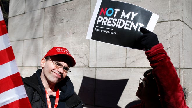 Tim Rosen, left, a President Donald Trump supporter, talks with Kathy Rosen at an anti-Trump rally in New York, Monday, Feb. 20, 2017. The New York rally is one of several "Not My President's Day" protests planned across the country to mark the President's Day holiday. (AP Photo/Seth Wenig)