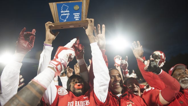 Paulsboro players and coaches raise their trophy after beating Salem 29-26 in the South Jersey Group 1 final Saturday at Rowan University.