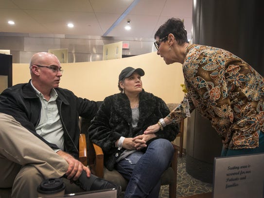 Jason Newton, left, of Handy Township waits in lobby of Karmanos Cancer Institute with his wife, Kimberlie Newton, 45, as Karmanos medical assistant Iris Burman retrieves Newton for her appointment Monday, March 12, 2018.