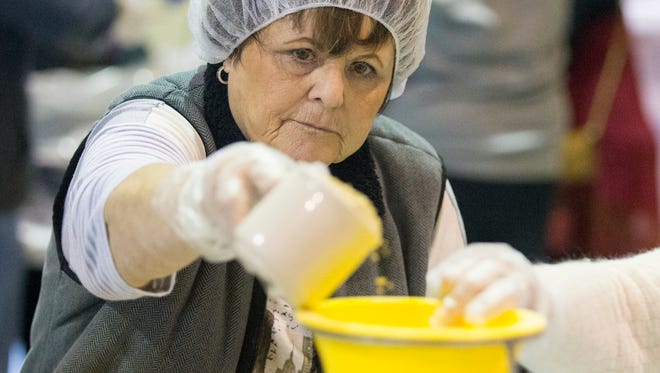 Patty Hedrick, Fairland, measured soy protein into a funnel for food packets that were being packed on Saturday, Jan. 17, 2015, at Lifepoint Church in Greenwood. The event was organized by Stop Hunger Now, a program that delivers nutritious food to impoverished areas worldwide.