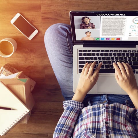 A person sitting cross-legged working remotely wit