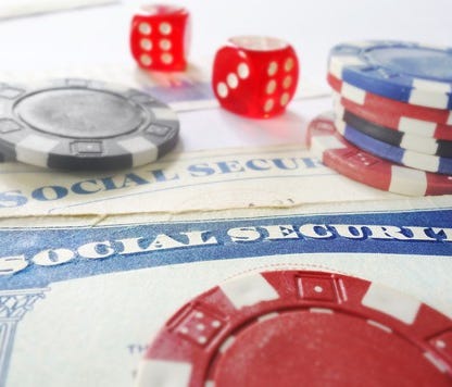 Casino chips and dice lying atop Social Security cards.