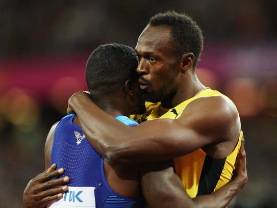 Usain Bolt of Jamaica embraces Justin Gatlin of the