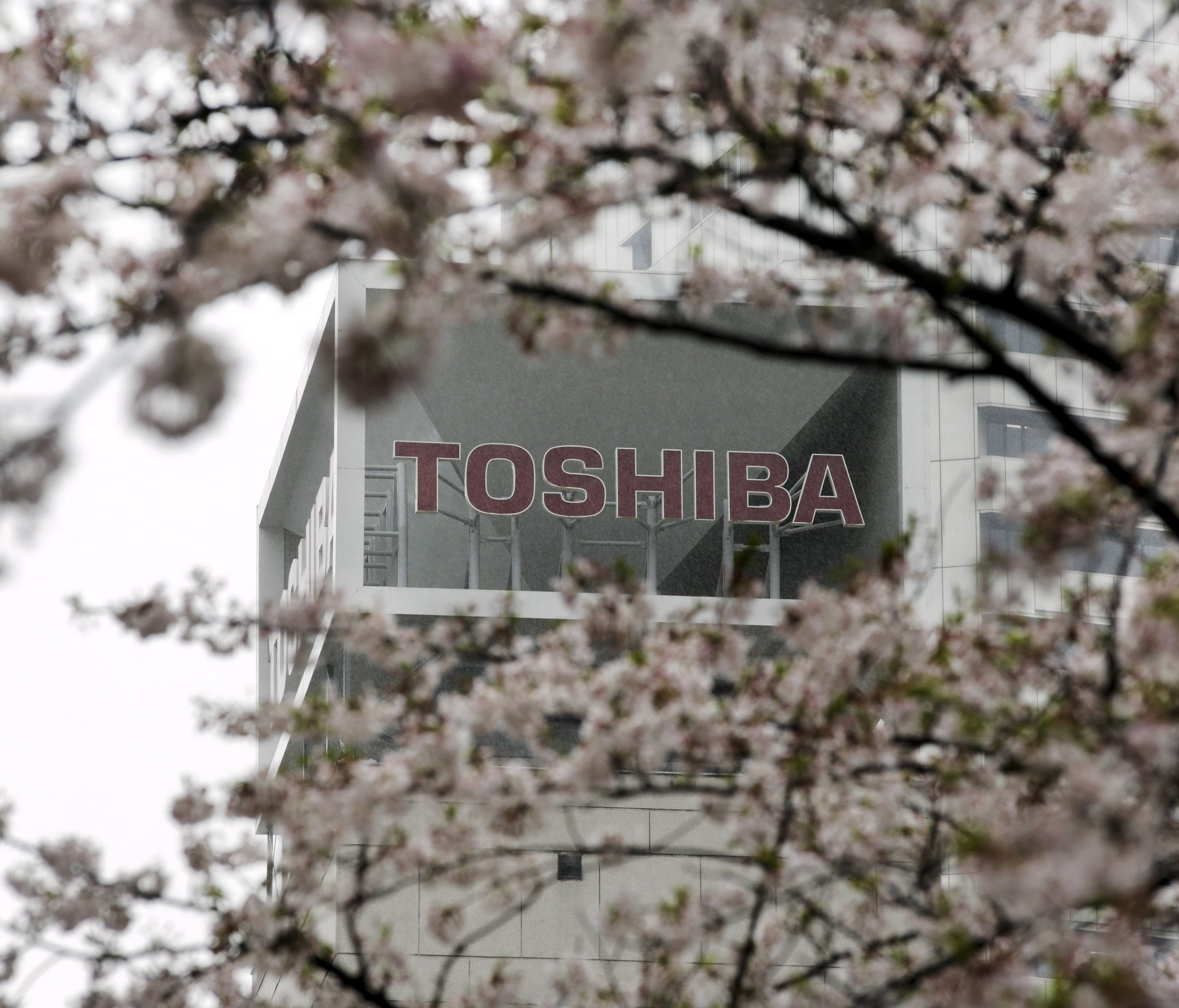 The logo of Toshiba Corp., with cherry blossoms in full bloom at its headquarters in Tokyo, Japan, April 11,  2017.