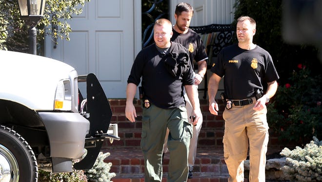Law enforcement officers leave the Carmel home of former American Senior Communities CEO James Burkhart during a criminal investigation on Tuesday, September 15, 2015.