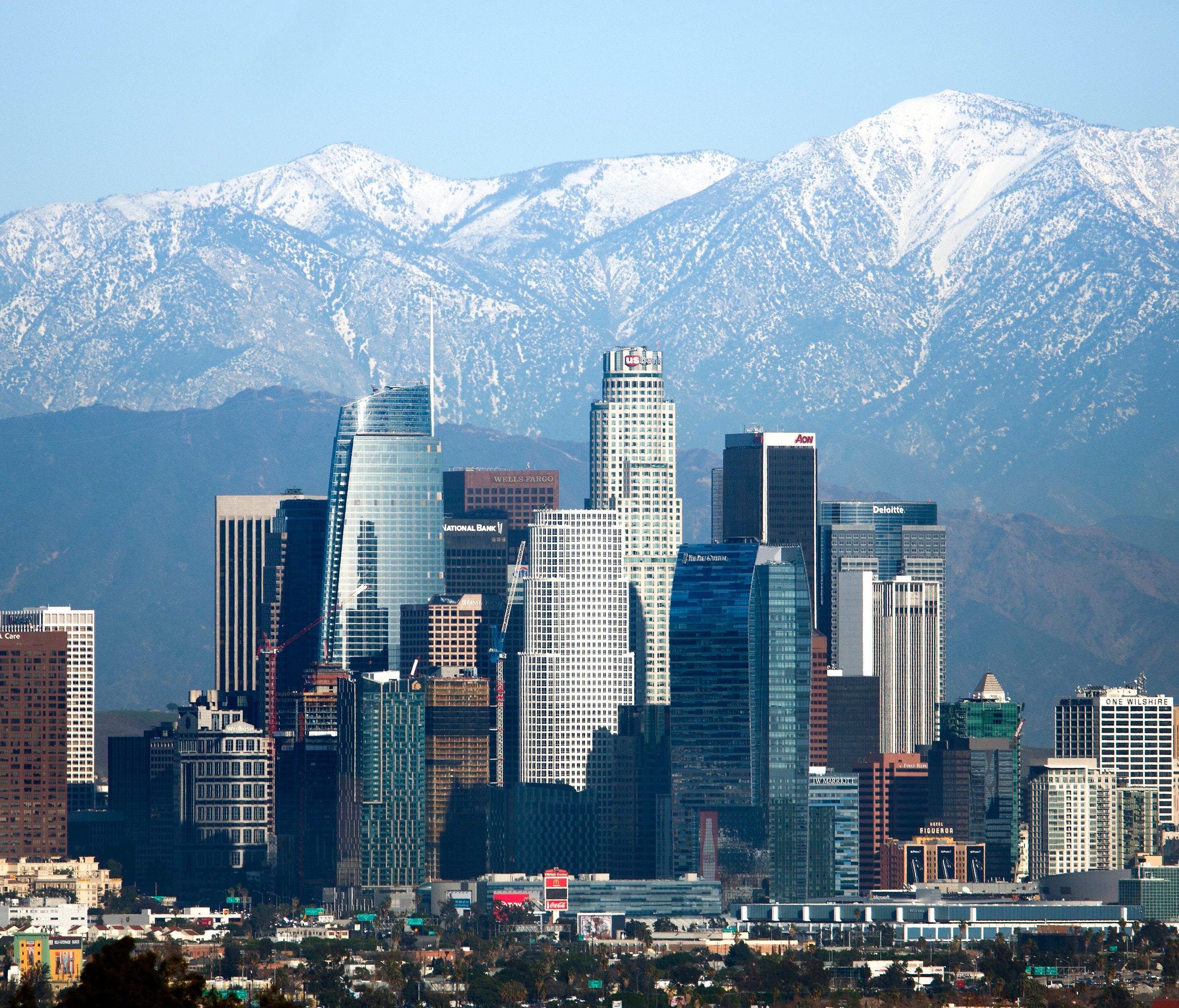 Snow-covered peaks on the San Gabriel mountains from recent storms frame the skyline of Los Angeles on Dec. 27, 2016.
