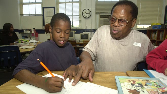 (News Journal file photo, 2001) School Board member Elmer Jenkins helps Hallmark student Shawn Jenkins, 10, with math assignment.