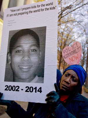 Tomiko Shine holds up a picture Dec. 1, 2014, of Tamir Rice, the 12-year-old boy fatally shot Nov. 22 by a rookie Cleveland police officer.